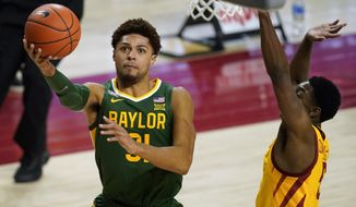 FILE - In this Saturday, Jan. 2, 2021, file photo, Baylor guard MaCio Teague drives to the basket ahead of Iowa State guard Jalen Coleman-Lands, right, during the second half of an NCAA college basketball game in Ames, Iowa. There really are no tougher matchups for Baylor guards Jared Butler, Davion Mitchell and MaCio Teague than in those countless hours they spend in the gym going 1-on-1 against each other. Or for opposing teams when that trio of guards is on the court together for the Bears, the Big 12 champions and a No. 1 seed in the NCAA Tournament for the first time. (AP Photo/Charlie Neibergall, File)