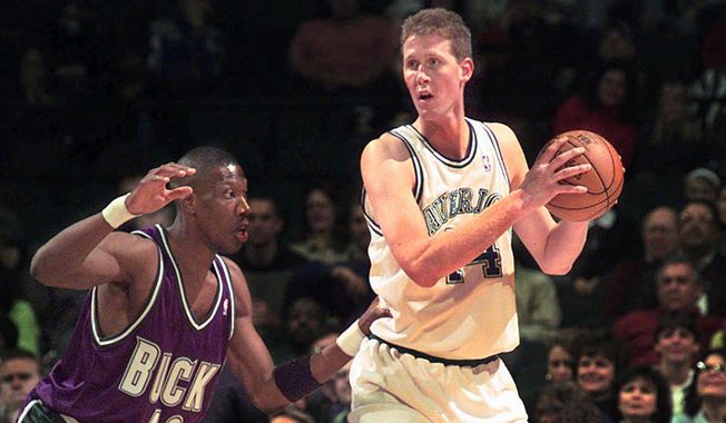 In this Nov. 22, 1997, file photo, Dallas Mavericks&#x27; Shawn Bradley (44) looks to pass as Milwaukee Bucks&#x27; Ervin Johnson (40) defends during the first quarter of an NBA basketball game at the Reunion Arena in Dallas. Former NBA player Shawn Bradley was paralyzed when he was struck from behind by a vehicle while riding a bike near his Utah home, saying in a statement nearly two months after the accident he intended to bring awareness to bicycle safety. (AP Photo/LM Otero, File) **FILE**