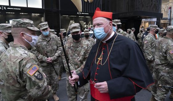 Cardinal Timothy Dolan, center, greets members of the New York National Guard who participated in the St. Patrick&#x27;s Day Parade outside St. Patrick&#x27;s Cathedral, Wednesday, March 17, 2021, in New York. (AP Photo/Mark Lennihan) ** FILE **