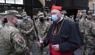 Cardinal Timothy Dolan, center, greets members of the New York National Guard who participated in the St. Patrick&#39;s Day Parade outside St. Patrick&#39;s Cathedral, Wednesday, March 17, 2021, in New York. (AP Photo/Mark Lennihan) ** FILE **