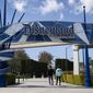 FILE - In this March 9, 2021, file photo, two visitors enter Disneyland Resort in Anaheim, Calif.  Disneyland announced Wednesday, March 17, that Disneyland and Disney California Adventure will reopen on April 30 with limited capacity. (AP Photo/Jae C. Hong, File)