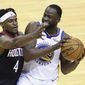 Golden State Warriors&#39; Draymond Green keeps the ball from Houston Rockets&#39; Danuel House Jr. during the first quarter of an NBA basketball game Wednesday, March 17, 2021, in Houston. (Carmen Mandato/Pool Photo via AP)