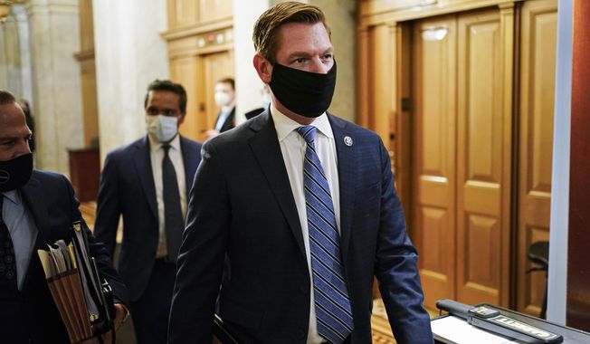 In this Feb. 10, 2021, file photo, Rep. Eric Swalwell, D-Calif., walks at the Capitol, in Washington. The House has rejected an attempt to boot a Democrat from the House intelligence committee. Democrats scuttled a Republican effort to remove Swalwell from the intelligence panel. The resolution against Swalwell cited reporting that he had contact more than six years ago with a suspected Chinese spy who targeted politicians in California. (Joshua Roberts/Pool via AP, File)