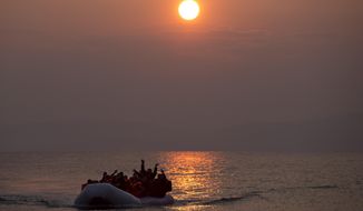 FILE - In this Sunday, March 20, 2016 file photo, the sun rises as migrants and refugees on a dinghy arrive at the shore of the northeastern Greek island of Lesbos, after crossing the Aegean sea from Turkey. Five years on, the deal between European Union and Turkey is no longer working but at a summit next week EU leaders will discuss ways to improve relations with Turkey and could try to revive the agreement. (AP Photo/Petros Giannakouris, File)