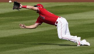 Los Angeles Angels&#39; Mike Trout catches a fly out by Cincinnati Reds&#39; Kyle Holder during the inning of a spring training baseball game, Monday, March 15, 2021, in Tempe, Ariz. (AP Photo/Matt York)