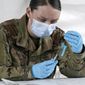 In this file photo, U.S. Army medic Kristen Rogers of Waxhaw, N.C. fills syringes with the Johnson &amp; Johnson COVID-19 vaccine, Wednesday, March 3, 2021, in North Miami, Fla.  (AP Photo/Marta Lavandier)  **FILE**