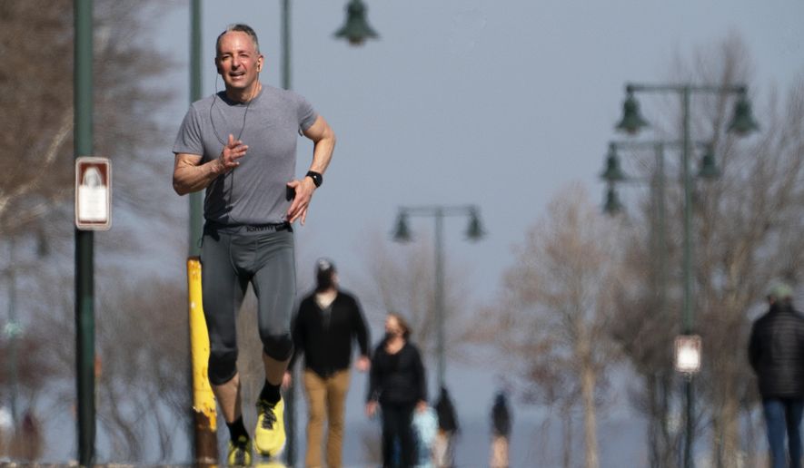 A jogger takes advantage of T-shirt weather on an spring-like day with temperatures in the mid-50s Fahrenheit, Thursday March 11, 2021, in Portland, Maine. (AP Photo/Robert F. Bukaty)