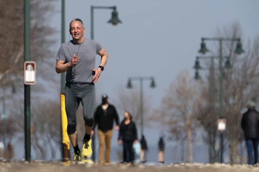 A jogger takes advantage of T-shirt weather on an spring-like day with temperatures in the mid-50s Fahrenheit, Thursday March 11, 2021, in Portland, Maine. (AP Photo/Robert F. Bukaty)