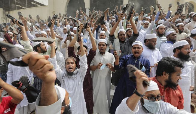 Bangladeshis raise their footwear and shout slogans during a protest after Friday prayers, against the visit of Indian Prime Minister Narendra Modi in Dhaka, Bangladesh, Friday, March 19, 2021. Hundreds of people including Muslim devotees and left-leaning student activists on Friday rallied in Bangladesh&#x27;s capital to denounce the upcoming visit of Indian Prime Minister Narendra Modi to join the celebration of the country&#x27;s 50th anniversary of independence. (AP Photo/Mahmud Hossain Opu)