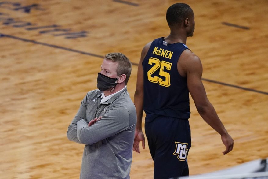 Marquette head coach Steve Wojciechowski, left watches his team play as Koby McEwen (25) heads to the bench after fouling out of the game during the second half of an NCAA college basketball game against Georgetown in the Big East conference tournament Wednesday, March 10, 2021, in New York. Georgetown won 68-49. (AP Photo/Frank Franklin II)