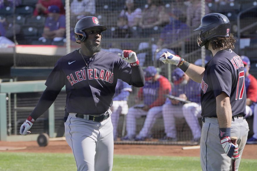 Cleveland Indians' Daniel Johnson, left, gets a fist bump from teammate Austin Hedges (17) after his a spring training baseball game Tuesday, March 9, 2021, in Surprise, Ariz. (AP Photo/Sue Ogrocki)