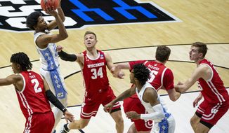 North Carolina&#39;s Kerwin Walton, second from left, shoots between Wisconsin&#39;s Aleem Ford (2) and Brad Davison (34) during the first half of a first-round game in the NCAA men&#39;s college basketball tournament, Friday, March 19, 2021, at Mackey Arena in West Lafayette, Ind. (AP Photo/Robert Franklin)