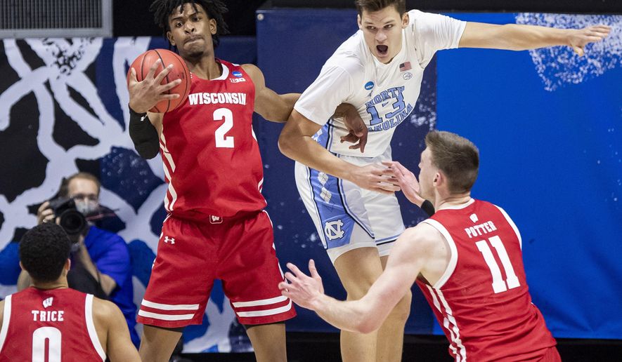 Wisconsin&#39;s Aleem Ford (2) grabs a rebound next to North Carolina&#39;s Walker Kessler (13) during the first half of a first-round game in the NCAA men&#39;s college basketball tournament Friday, March 19, 2021, at Mackey Arena in West Lafayette, Ind. (AP Photo/Robert Franklin)