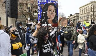 A protester holds up a painting of Breonna Taylor during a rally on the one year anniversary of her death at Jefferson Square Park in Louisville, Ky., Saturday, March 13, 2021. (AP Photo/Timothy D. Easley)