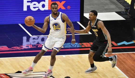 Golden State Warriors forward Andrew Wiggins (22) handles the ball against Memphis Grizzlies guard De&#39;Anthony Melton (0) in the first half of an NBA basketball game Friday, March 19, 2021, in Memphis, Tenn. (AP Photo/Brandon Dill)