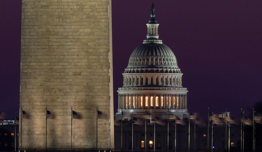 The Capitol is seen beyond the base of the Washington Monument before sunrise in Washington, Wednesday, March 10, 2021. (AP Photo/Carolyn Kaster)