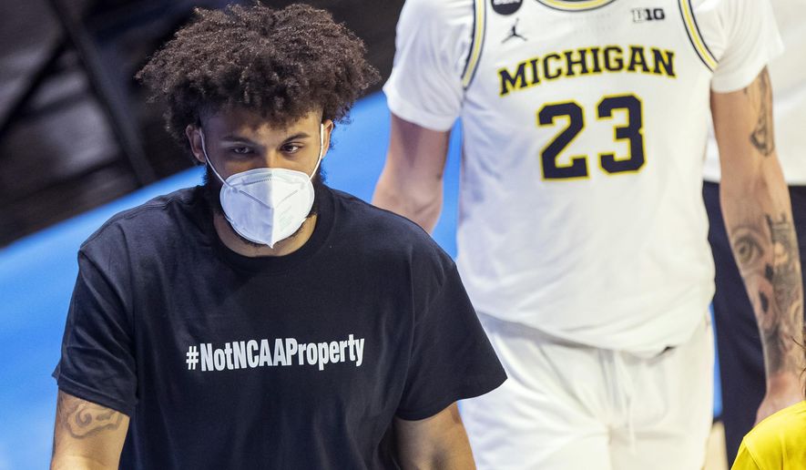 Michigan&#39;s Isaiah Livers wears a T-shirt that reads &amp;quot;#NotNCAAProperty&amp;quot; as he walks off the court with teammates after the first half of a first-round game against Texas Southern in the NCAA men&#39;s college basketball tournament, Saturday, March 20, 2021, at Mackey Arena in West Lafayette, Ind. (AP Photo/Robert Franklin)