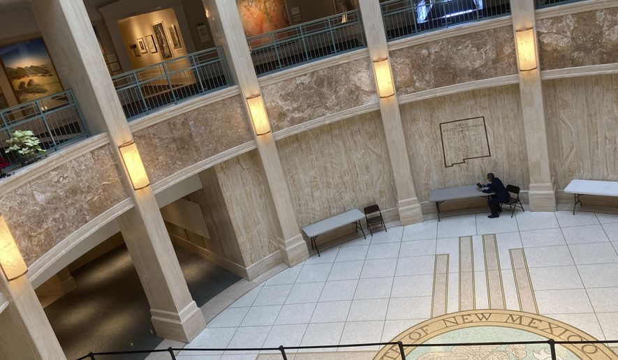 Democratic state Rep. Roger Montoya of Velarde works on a laptop in the state Capitol rotunda in Santa Fe, N.M., in the final hours of a 60-day legislative session on Saturday, March 20, 2021. The Democrat-led Legislature has charted an economic exit from the COVID-19 pandemic and checked off progressive priorities on policing reforms, abortion rights, medical aid in dying and child poverty. (AP Photo/Morgan Lee)