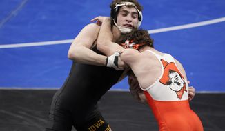 Oklahoma State&#39;s Daton Fix, right, takes on Iowa&#39;s Austin DeSanto during their 133-pound match in the semifinal round of the NCAA wrestling championships Friday, March 19, 2021, in St. Louis. (AP Photo/Jeff Roberson)