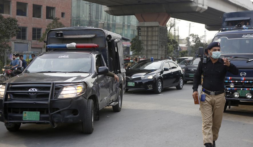 A police officer clears way for a convoy of an anti-terrorism court judge Arshad Hussain Butta arriving at district jail, where the special court setup for the trial of prime suspects in motorway gang-rape case, in Lahore, Pakistan, Saturday, March 20, 2021.    A prosecutor says an anti-terrorism court in Pakistan has awarded death penalty and 14 year jail terms to two men held for motorway gang rape of a woman in front of her children last year in eastern Punjab province.  (AP Photo/K.M. Chaudary)