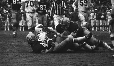 Philadelphia Eagle Cyril Pinder (22) is caught between two Washington Redskins, Jon Jaqua, bottom, and Russell Tillman, during first quarter action at RFK Stadium, Dec. 13, 1970, Washington, D.C. (AP Photo/John Duricka) **FILE**