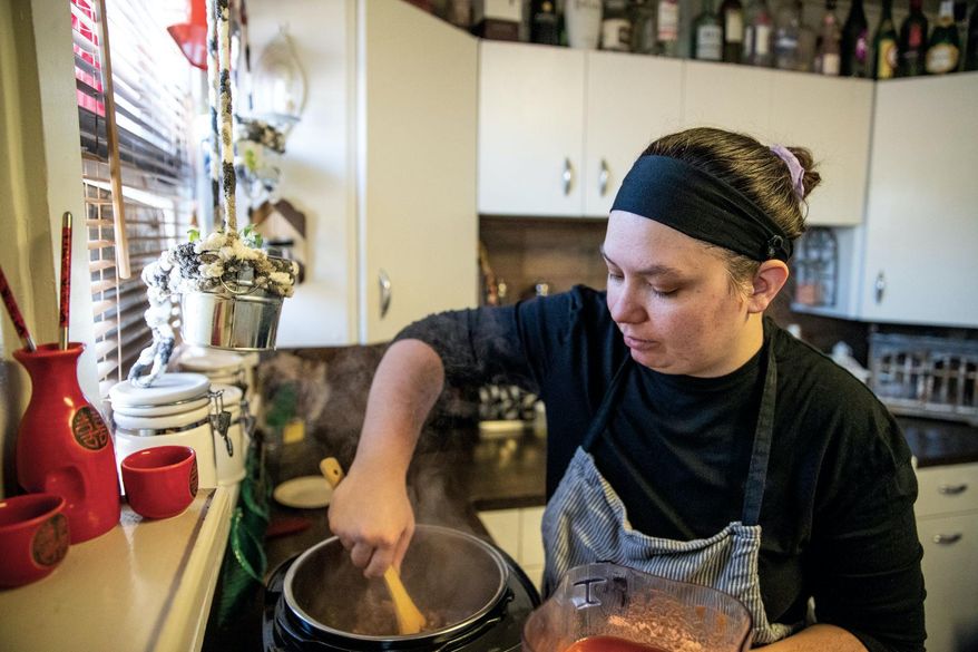 Kasi Hartsoch stirs chili in her home while preparing food for her YouFeed home kitchen business, on Feb. 24, 2021, in Gillette, Wyo. (Mike Moore/Gillette News Record via AP)