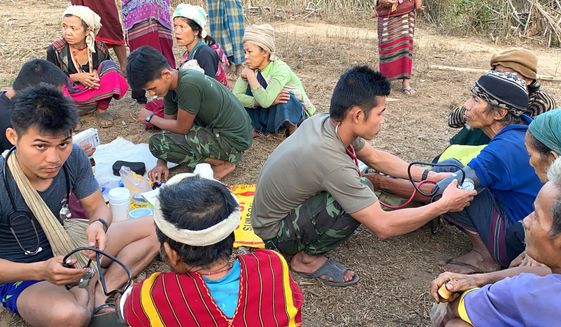 In this photo released by the Free Burma Rangers, members of the humanitarian group Free Burma Rangers carry out medical checkups on villagers in the northern Karen State, Myanmar Feb. 25, 2021. The group has been bringing aid to some of the 8,000 ethnic people forced to flee their homes by an ongoing local offensive by the Myanmar army aimed at increasing the military’s presence in the remote region. (Free Burma Rangers via AP)