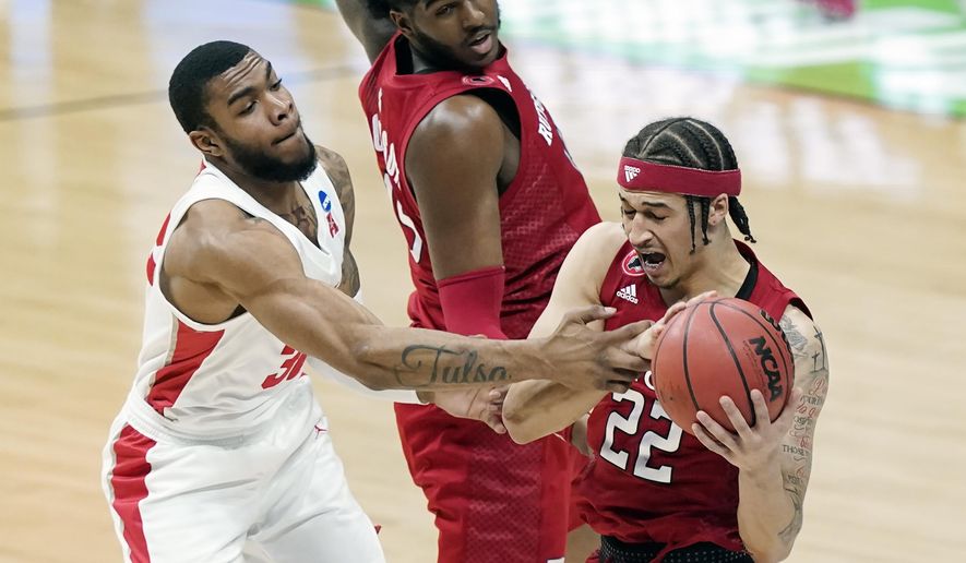 Houston&#39;s Reggie Chaney, left, grabs Rutgers&#39; Caleb McConnell (22) during the first half of a college basketball game in the second round of the NCAA tournament at Lucas Oil Stadium in Indianapolis Sunday, March 21, 2021. (AP Photo/Mark Humphrey)