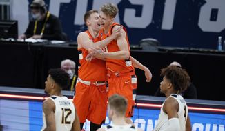 Syracuse&#39;s Buddy Boeheim (35) ad Marek Dolezaj (21) celebrate following a second-round game against West Virginia in the NCAA men&#39;s college basketball tournament at Bankers Life Fieldhouse, Sunday, March 21, 2021, in Indianapolis. Syracuse defeated Syracuse 75-72. (AP Photo/Darron Cummings)