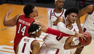 Arkansas forward Justin Smith (0) grabs a rebound from Texas Tech forward Marcus Santos-Silva (14) in the first half of a second-round game in the NCAA men&#39;s college basketball tournament at Hinkle Fieldhouse in Indianapolis, Sunday, March 21, 2021. (AP Photo/Michael Conroy)