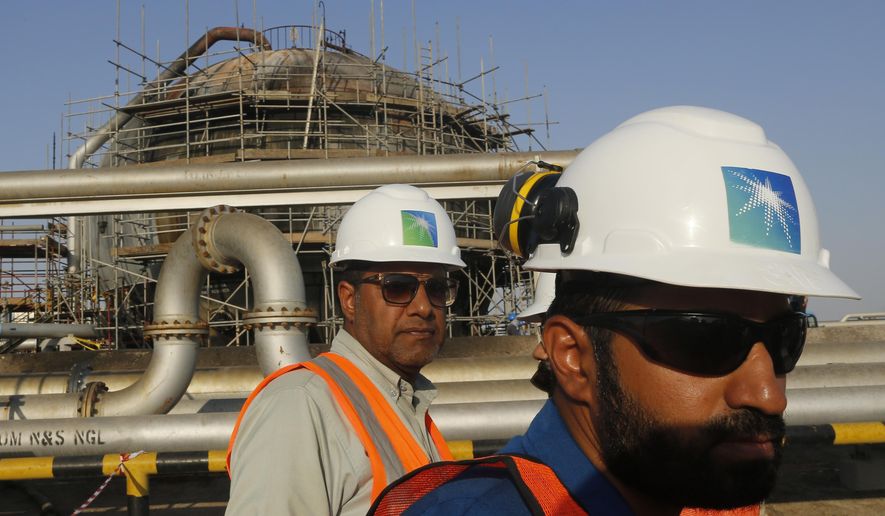 In this Sept. 20, 2019, file photo, engineers walk in front of an oil separator at a Saudi Aramco processing facility in Abqaiq, Saudi Arabia. Saudi Arabia&#39;s state-backed oil giant Aramco announced Sunday, March 21, 2021, that its 2020 profits fell sharply in 2020 to $49 billion, a big drop that came as the coronavirus pandemic roiled global energy markets. (AP Photo/Amr Nabil, File)