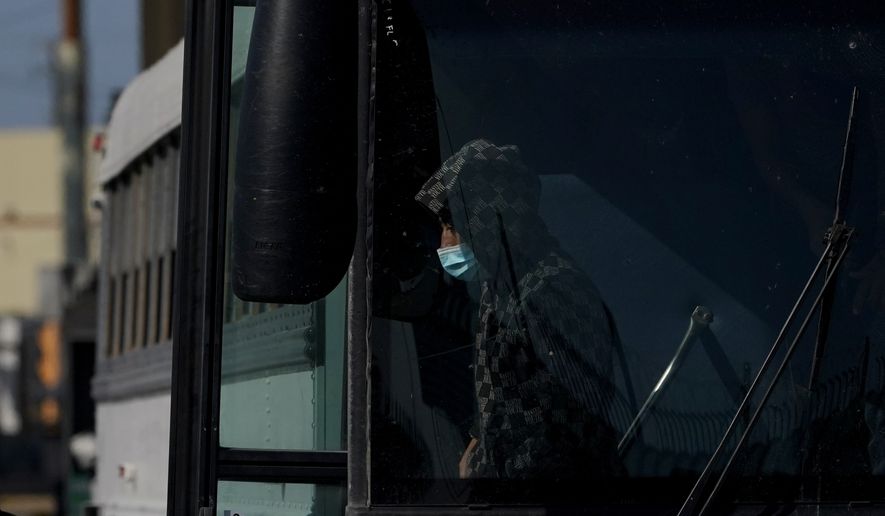 A migrant wears a face mask to protect against COVID-19 while walking off a U.S. Customs and Border Protection bus at the McAllen-Hidalgo International Bridge as he is deported to Mexico, Saturday, March 20, 2021, in Hidalgo, Texas. The fate of thousands of migrant families who have recently arrived at the Mexico border is being decided by a mysterious new system under President Joe Biden. U.S. authorities are releasing migrants with acute vulnerabilities and allowing them to pursue asylum. But it&#39;s not clear why some are considered vulnerable and not others. (AP Photo/Julio Cortez)