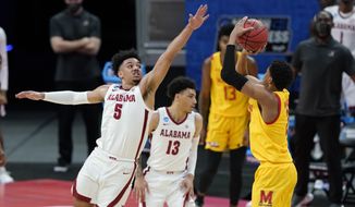Alabama&#39;s Jaden Shackelford (5) tries to block the shot of Maryland&#39;s Aaron Wiggins (2) during the first half of a college basketball game in the second round of the NCAA tournament at Bankers Life Fieldhouse in Indianapolis Monday, March 22, 2021. (AP Photo/Mark Humphrey)