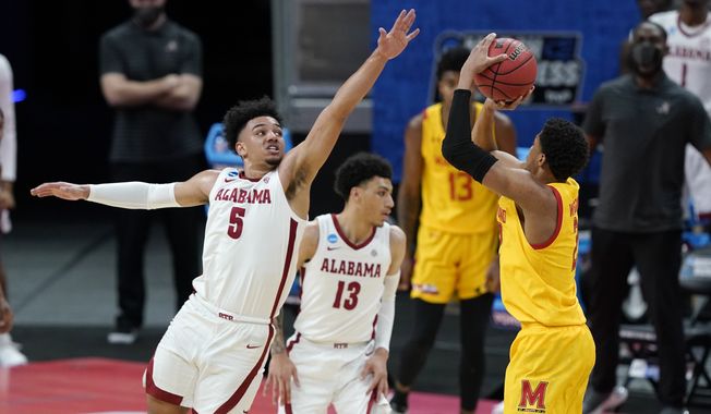 Alabama&#x27;s Jaden Shackelford (5) tries to block the shot of Maryland&#x27;s Aaron Wiggins (2) during the first half of a college basketball game in the second round of the NCAA tournament at Bankers Life Fieldhouse in Indianapolis Monday, March 22, 2021. (AP Photo/Mark Humphrey)