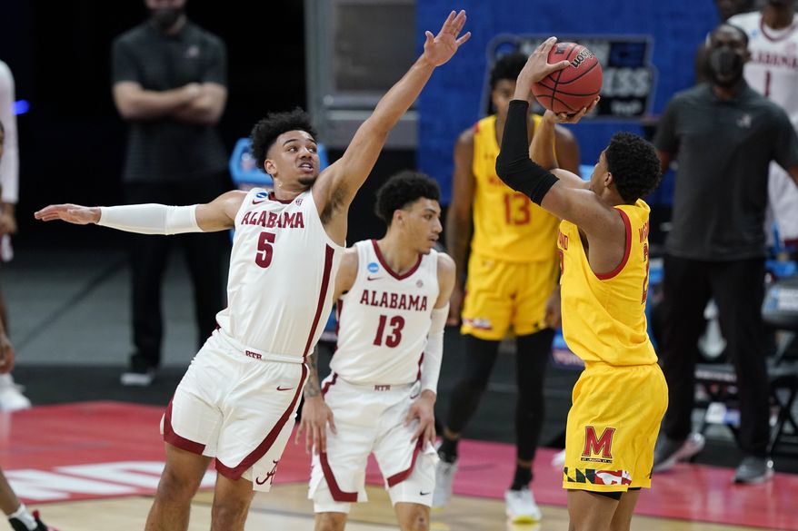 Alabama&#39;s Jaden Shackelford (5) tries to block the shot of Maryland&#39;s Aaron Wiggins (2) during the first half of a college basketball game in the second round of the NCAA tournament at Bankers Life Fieldhouse in Indianapolis Monday, March 22, 2021. (AP Photo/Mark Humphrey)
