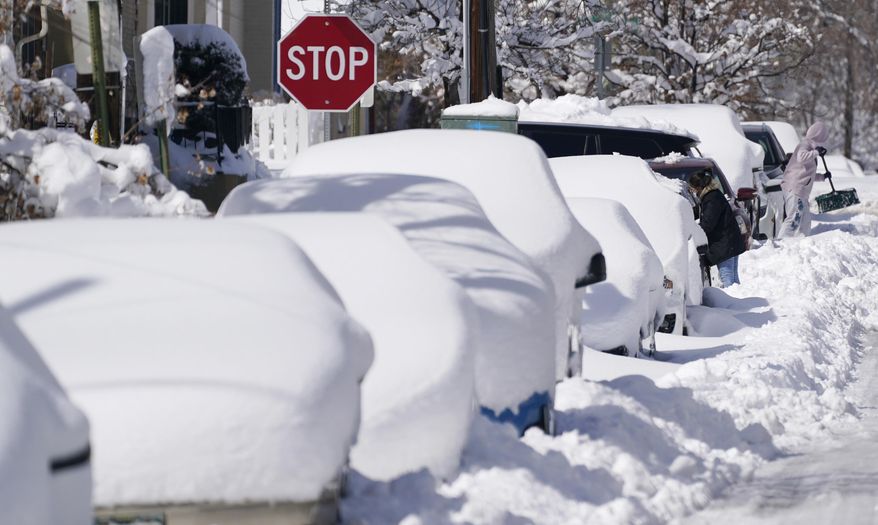 FILE - In this Monday, March 15, 2021 file photo, snow covers vehicles parked along Second Avenue after a powerful late winter storm dumped more than 2 feet of snow in Denver. The storm shut down major roadways, canceled school and closed the state legislature. On Monday, March 22, 2021, the National Weather Service upgraded its forecast model, with an eye on predicting extreme weather events better and faster. (AP Photo/David Zalubowski)