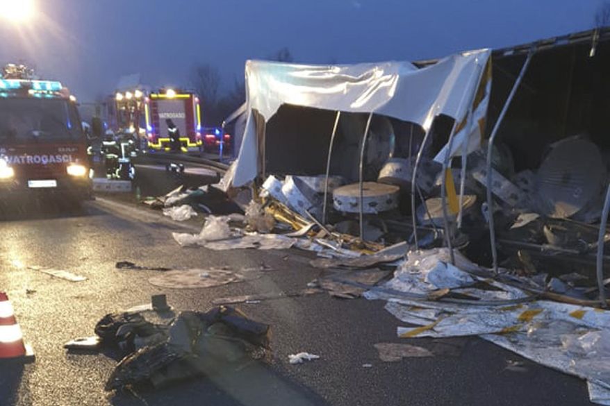 In this photo provided by Novska Fire Brigade, emergency services at the site of an overturned truck trailer on the motorway near Okucani, Croatia, Monday, March 22, 2021. A truck has overturned in Croatia killing four migrants who were hiding inside and injuring a number of others. Croatian police say the accident happened early on Monday on a motorway near the border with Bosnia. They say the truck had Serbian license plates. Croatian state HRT television says the truck was transporting tons of heavy paper rolls which crushed some of the migrants when the truck overturned. (Novska Fire Brigade via AP)