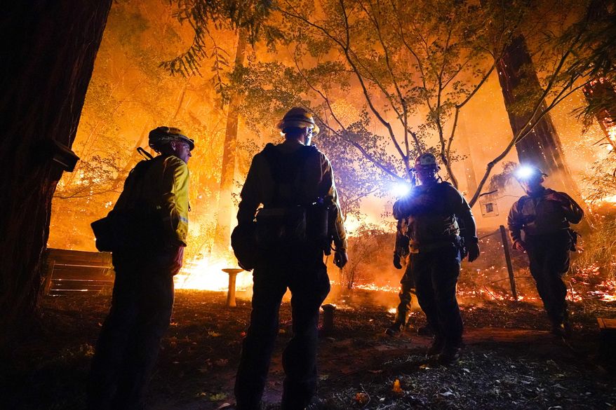 FILE - In this Aug. 21, 2020, file photo, firefighters make a stand in the backyard of a home in front of the advancing CZU August Lightning Complex Fire Friday, in Boulder Creek, Calif. (AP Photo/Marcio Jose Sanchez, File)