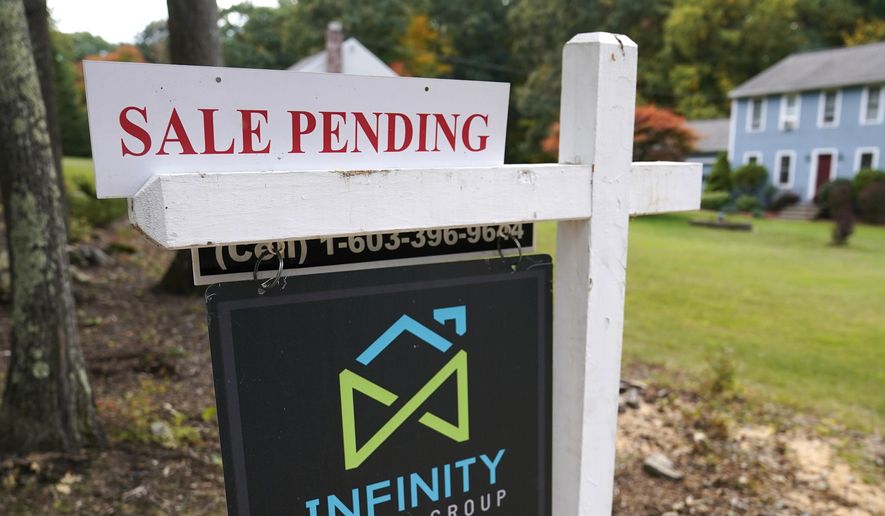 FILE - In this Sept. 29, 2020 file photo, a sale pending sign is displayed outside a residential home for sale in East Derry, N.H. Sales of previously occupied U.S. homes slowed last month as rising prices and a dearth of homes for sale kept some would-be buyers on the sidelines.  (AP Photo/Charles Krupa, File)
