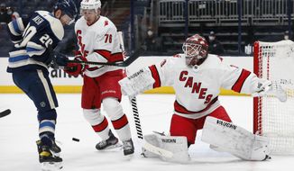 Carolina Hurricanes&#x27; Alex Nedeljkovic, right, makes a save as teammate Brady Skjei, center, and Columbus Blue Jackets&#x27; Riley Nash look for the puck during the second period of an NHL hockey game Monday, March 22, 2021, in Columbus, Ohio. (AP Photo/Jay LaPrete)