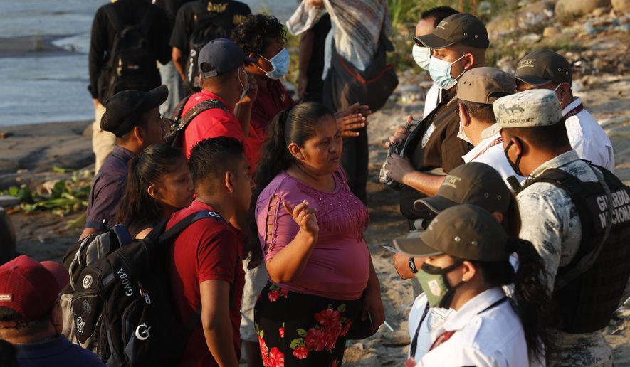 Mexican immigration agents stop people who crossed the Suchiate River, the natural border between Guatemala and Mexico, to see their identification documents as they enforce limits on all but essential travel near Ciudad Hidalgo, Mexico, Monday, March 22, 2021. Agents are forcing those with permission to enter Mexico for work or a visit to use the official border crossing bridge and others are being returned to Guatemala. (AP Photo/Eduardo Verdugo)