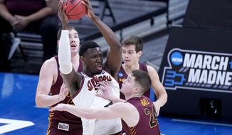 Illinois&#39; Kofi Cockburn, center, is defended by Loyola of Chicago&#39;s Tate Hall (24) during the first half of a college basketball game in the second round of the NCAA tournament at Bankers Life Fieldhouse in Indianapolis Sunday, March 21, 2021. (AP Photo/Mark Humphrey)