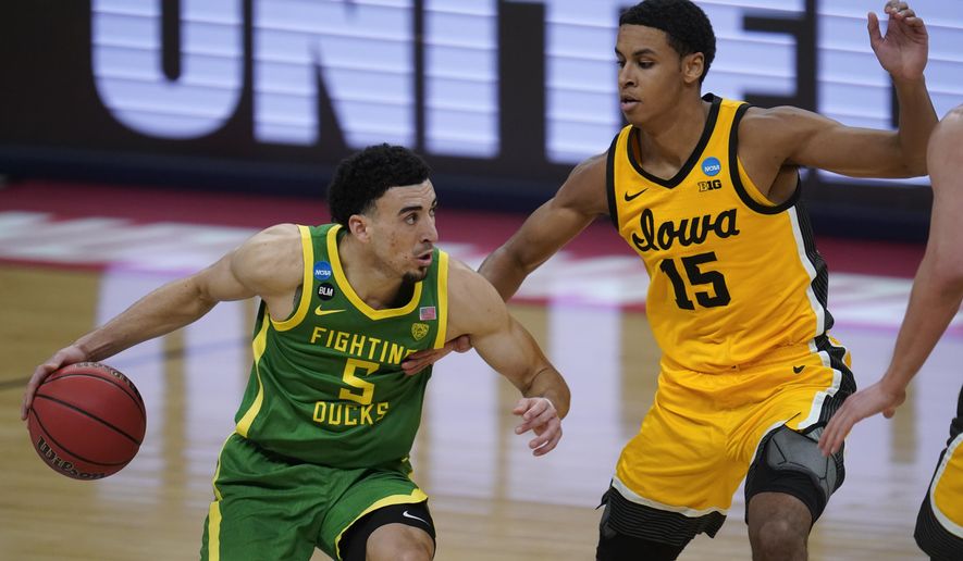 Oregon guard Chris Duarte (5) drives on Iowa forward Keegan Murray (15) during the second half of a men&#39;s college basketball game in the second round of the NCAA tournament at Bankers Life Fieldhouse in Indianapolis, Monday, March 22, 2021. (AP Photo/Paul Sancya)