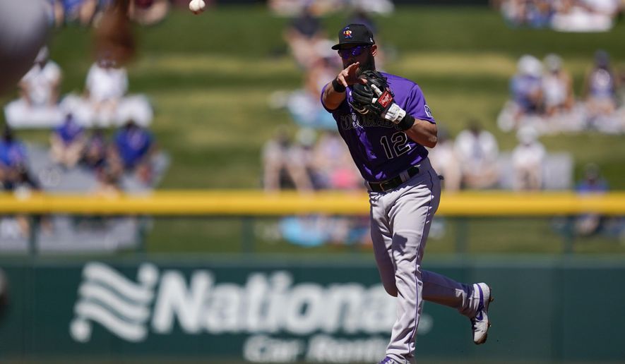 Colorado Rockies second baseman Chris Owings (12) throws to first to out Chicago Cubs' Joc Pederson during the first inning of a spring training baseball game Saturday, March 20, 2021, in Mesa, Ariz. (AP Photo/Ashley Landis)