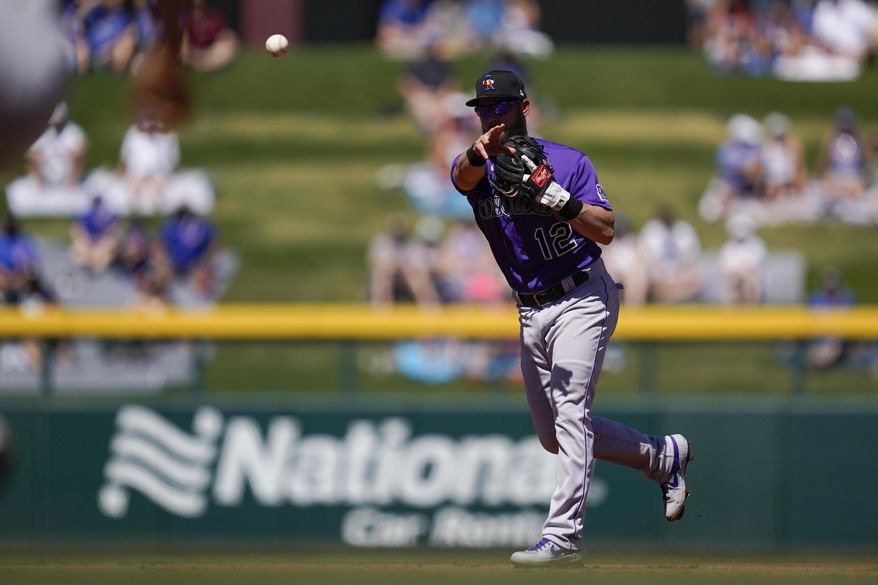 Colorado Rockies second baseman Chris Owings (12) throws to first to out Chicago Cubs' Joc Pederson during the first inning of a spring training baseball game Saturday, March 20, 2021, in Mesa, Ariz. (AP Photo/Ashley Landis)
