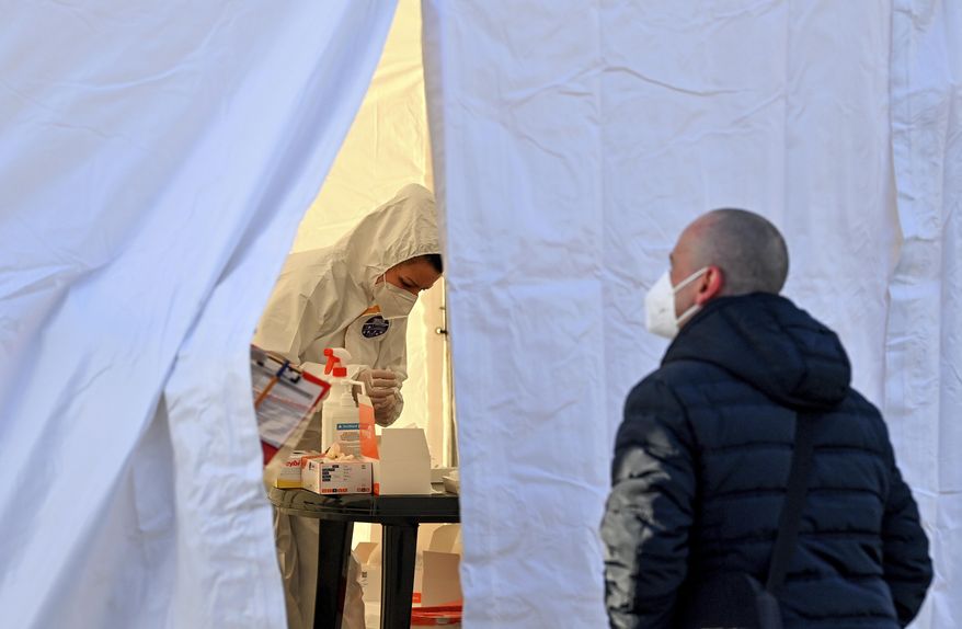 Polish commuters stands in front of a tent and waits for a coronavirus test at the Stadtbruecke border crossing between Germany and Poland in Frankfurt an der Oder, Germany, Monday, March, 22, 2021. Poland is being classified as a &#39;high risk&#39; COVID-19 area by German authorities and people crossing into Germany from Poland must provide a negative coronavirus test. (Patrick Pleul/dpa via AP)