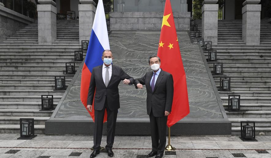 In this photo released by China&#x27;s Xinhua News Agency, Russian Foreign Minister Sergei Lavrov, left, meets with Chinese Foreign Minister Wang Yi in Guilin in southern China&#x27;s Guangxi Zhuang Autonomous Region, Monday, March 22, 2021. (Lu Boan/Xinhua via AP)