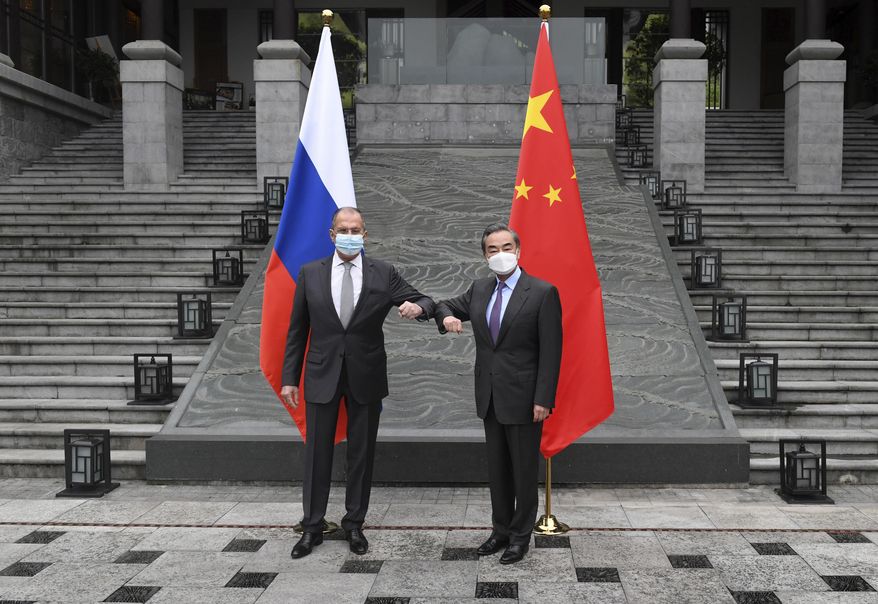 In this photo released by China&#39;s Xinhua News Agency, Russian Foreign Minister Sergei Lavrov, left, meets with Chinese Foreign Minister Wang Yi in Guilin in southern China&#39;s Guangxi Zhuang Autonomous Region, Monday, March 22, 2021. (Lu Boan/Xinhua via AP)