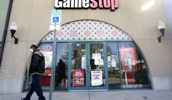 FILE - In this Jan. 28, 2021 file photo, a pedestrian passes a GameStop storefront in Dallas. A hefty tax benefit helped drive GameStop’s fiscal fourth-quarter profit sharply higher, but the video-game retailer’s sales declined despite a surge in its online business. The company&#39;s latest results fell short of Wall Street’s expectations. (AP Photo/LM Otero, File)