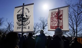 Hundreds gather along the Mississippi River in St. Paul, Minn., Thursday, March 11, 2021, to call on President Biden to stop the tar sands Line 3 pipeline that Enbridge is currently constructing in northern Minnesota. (AP Photo/Jim Mone)